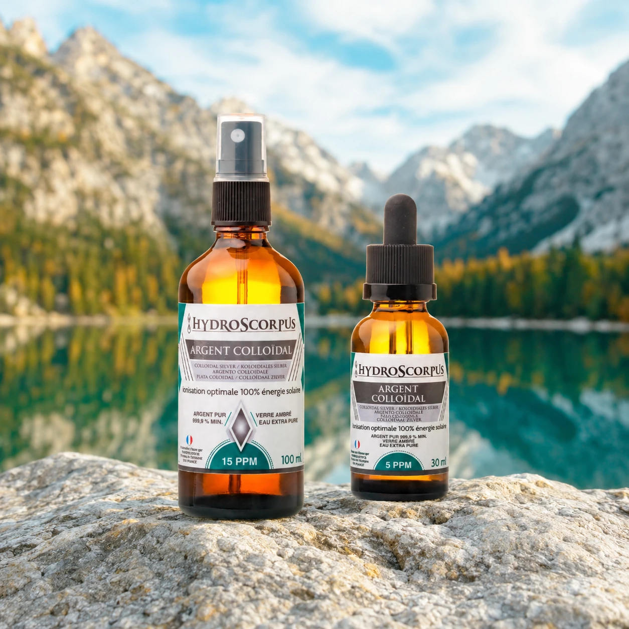 Pack Hydroscorpus spray argent colloïdal 15 PPM 100 ml et compte-gouttes 5 PPM 30 ml devant un lac et des montagnes.
